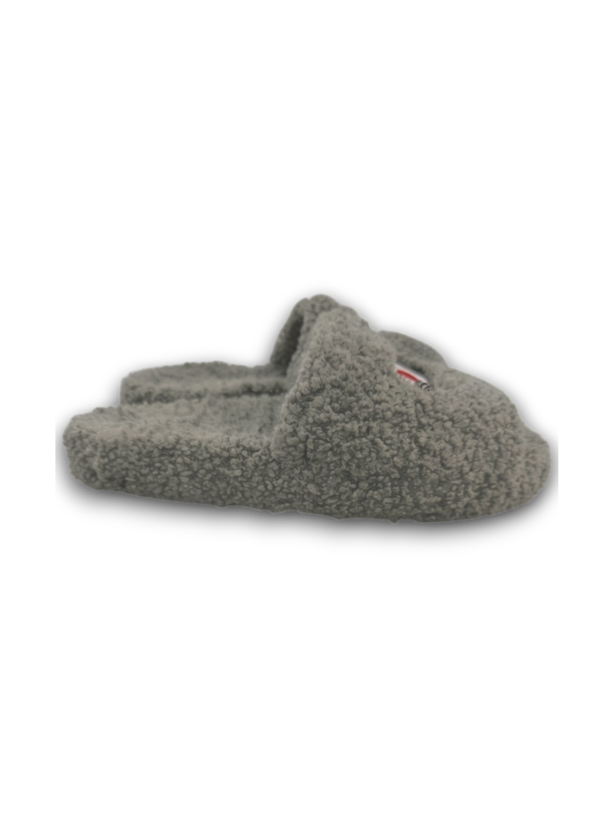 A pair of plush, fuzzy gray slide slippers with a small red and white embroidered flag detail on the side, shown against a plain white background.
