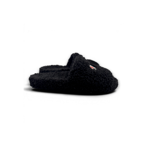 A single black fuzzy slip-on slight with a small red and white logo tab on the side, photographed on a white background.